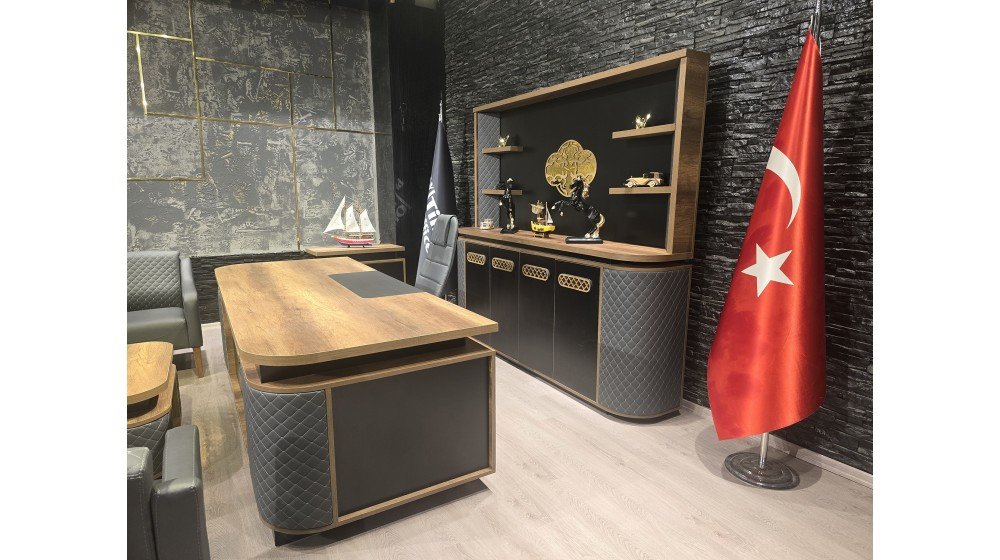 Kemer lüks yönetici masa takımı, gri kapitoneli panelleri, parlak altın rengi lazer kesim metal motifleri ve ceviz rengi tablası ile modern ofis ortamında sergileniyor.